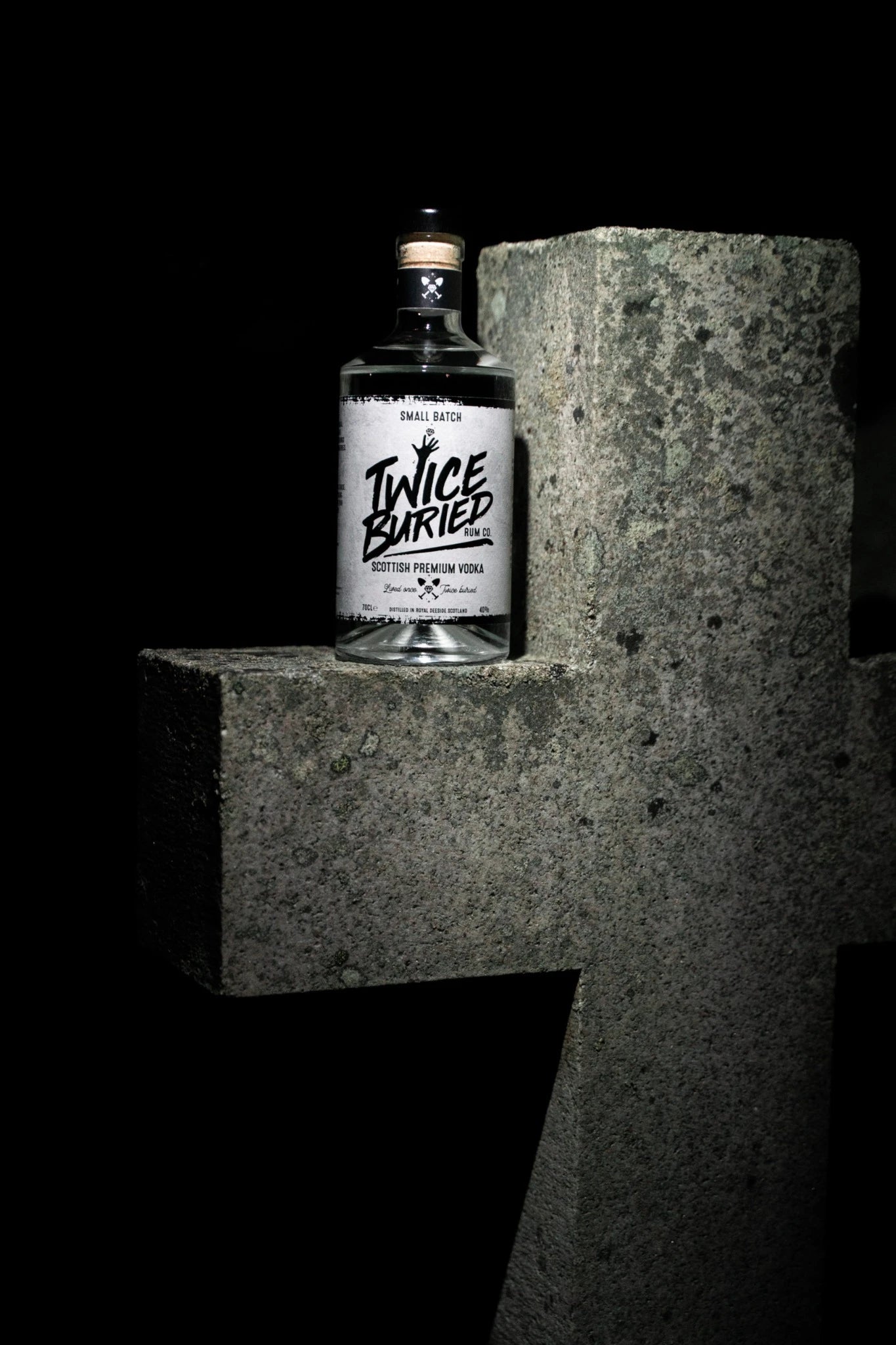 Twice Buried Vodka bottle on stone cross gravestone