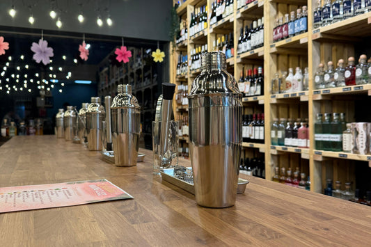 Alcohol bottles on shelves in a store with a wooden floor.