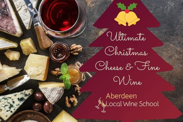 A festive flat-lay featuring an assortment of cheeses, a glass of red wine, and a large dark red Christmas tree graphic with the text 'Ultimate Christmas Cheese & Fine Wine' and 'Aberdeen Local Wine School.' The scene is styled with walnuts, olives, and a small bottle on a dark stone surface.